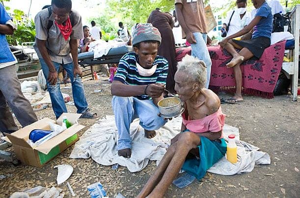 Haiti-earthquake-young-man-feeds-elderly-woman-011610-by-Timothy-Fadek-Polaris-for-TIME, The media called: Earthquake victims still await help, I say, World News & Views 