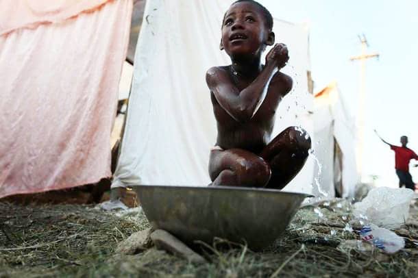 Haiti-earthquake-boy-bathes-in-washpan-PAP-012210-by-Getty, Three in a million: Voices from the Haitian camps, World News & Views 