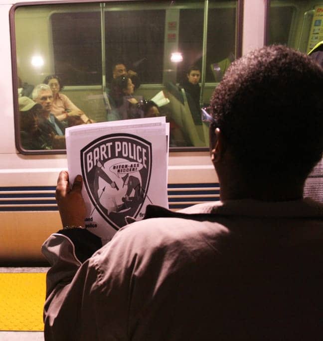 Oscar-Grant-Embarcadero-BART-protester-shows-Pirone-flier-to-passengers-040810-by-Reginald-James, Embarcadero BART protests keep spotlight on Justice for Oscar Grant movement, Local News & Views 