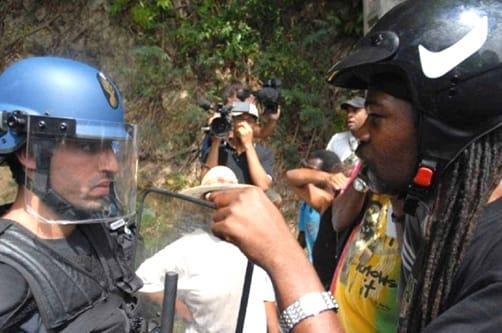 France sent hundreds of gendarmes – police – replete with riot gear to Guadeloupe to put down a month-long general strike demanding higher wages and lower prices but, despite the death of one of their leaders, the Guadeloupean people won’t back down. Like Haiti, the Caribbean islands of Guadeloupe and Martinique, also gripped by a general strike, are populated by the descendants of enslaved Africans and were colonized by France. Haitians revolted, defeating Napoleon’s armies in 1804, becoming the first Black independent country in the world. Guadeloupe and Martinique remain colonies. Though racism keeps all three islands dirt poor, it’s apparent in this confrontation that the people of Guadeloupe have plenty of pride and courage. - Photo: LKP